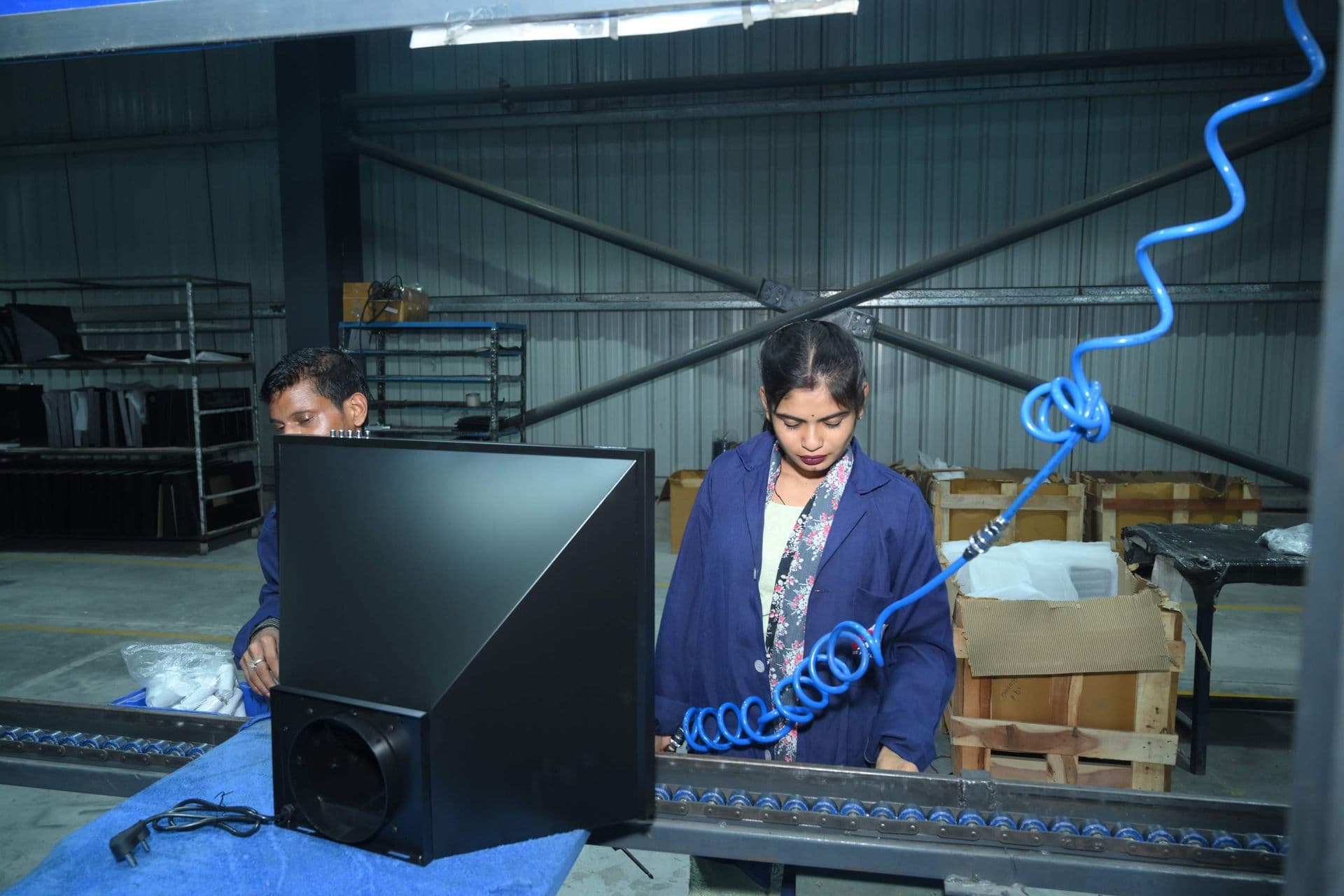 An operator fitting a kitchen hood body on the assembly line