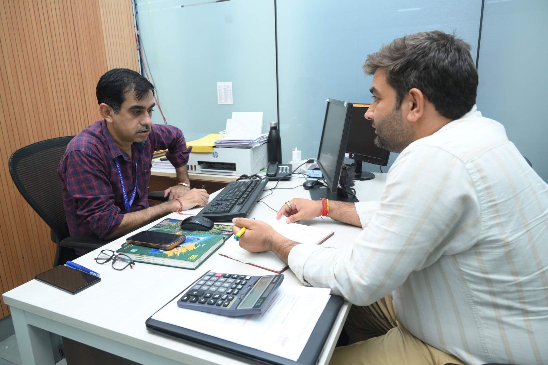 Two colleagues in a meeting at a desk in the plant office